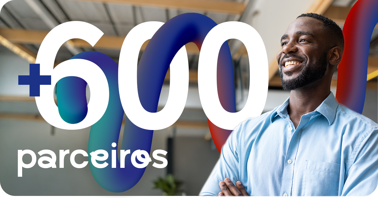 Painel com o número 600 e a palavra parceiros atravessados por uma fita colorida, ao lado da foto de um homem de braços cruzados